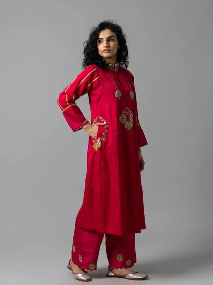 A vibrant red kurta set with quirky, embroidered motifs. The side pocket is a practical detail that I know my clients appreciate. This is a fun yet elegant choice for a festive day out.