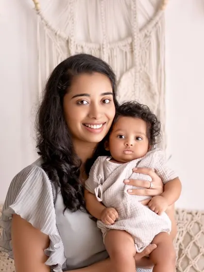 A mother holds her baby boy, who has the most beautiful curly hair. This is a simple, classic mother-and-child portrait that radiates warmth and love.