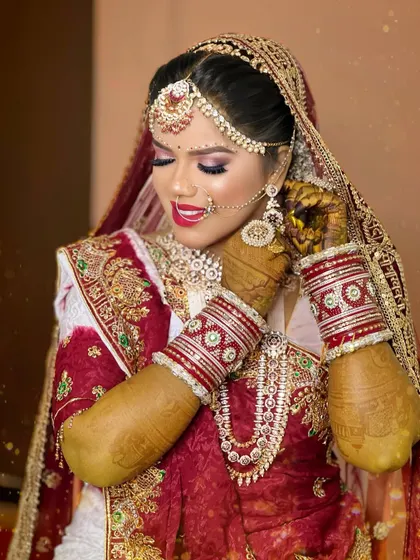 A close-up shot capturing the details of the hathphool, bangles, and the intricate work on her traditional Gujarati bridal attire.