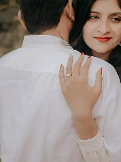 A close-up shot focusing on the bride-to-be's expression as she embraces her partner. The details, like her hand on his shoulder, tell a story of affection.
