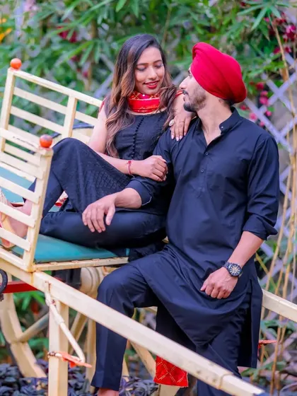 A playful moment on a traditional Indian cart. The couple's coordinated black outfits and their fun interaction make this a unique and memorable shot.