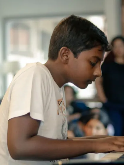 A young pianist completely focused during his recital performance. The dedication of our students is truly inspiring.