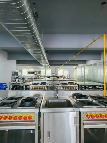 A wide view of our professional training kitchen, designed to simulate the environment of a high-end restaurant.