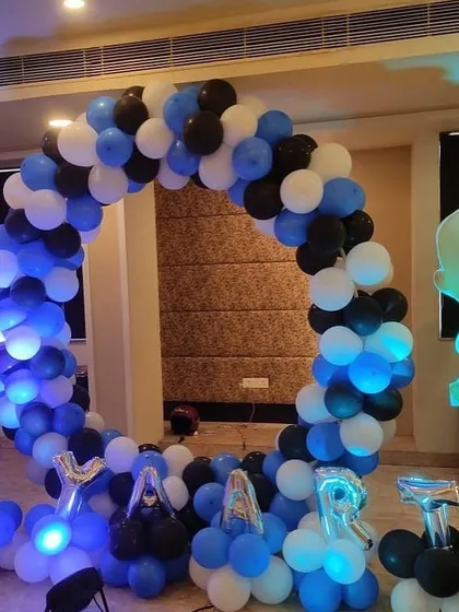 A Boss Baby themed circular balloon arch in blue, black, and white, perfect for a photo booth.