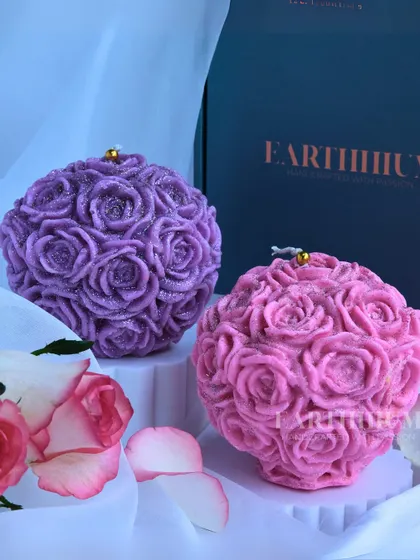 My rose ball candles are like a bouquet that never fades. This image shows the purple and pink versions, each covered in tiny, detailed roses with a hint of glitter.
