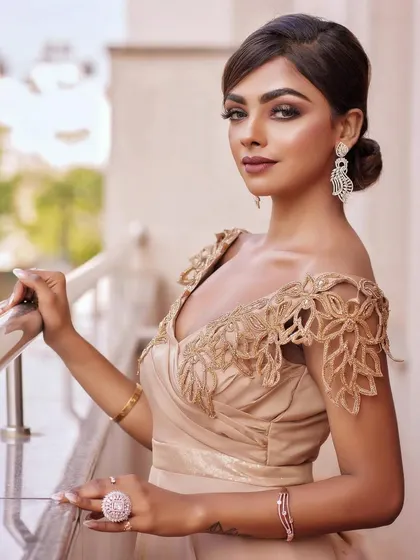 A portrait of the model on a balcony, looking effortlessly chic. The makeup is glamorous yet sophisticated, suitable for any high-end event.