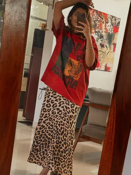 Styling a leopard print skirt in three ways. Look 1: Paired with a graphic tee for a pop-up event, showing an edgy, casual vibe.