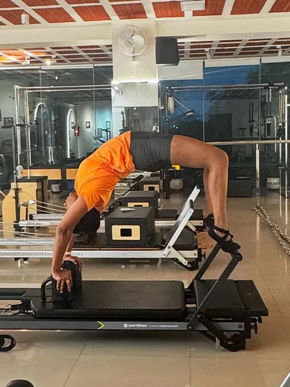 Let's get flexible. This full backbend, or wheel pose, on the reformer demonstrates incredible spinal mobility and shoulder strength.