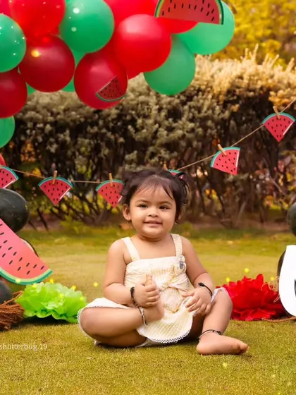 A fun watermelon-themed first birthday shoot in the park, perfect for a summer baby.