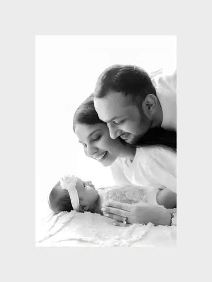 Stripped of color, this close-up of new parents admiring their baby is incredibly powerful. Every detail, from their soft smiles to the baby's tiny form, tells a story of love.