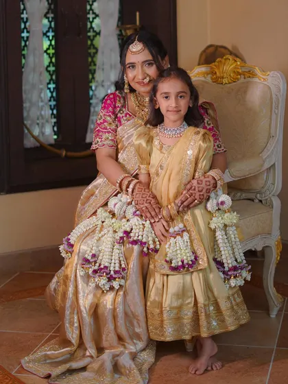 A beautiful family portrait. The matching floral jewellery for mother and daughter adds a lovely, coordinated element to their traditional outfits.