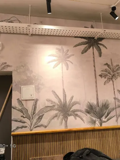 A view of the palm tree mural showing the seamless application across a long wall.