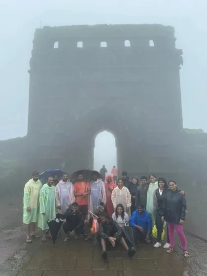 The group posing in front of the main gate of a fort, shrouded in thick fog.