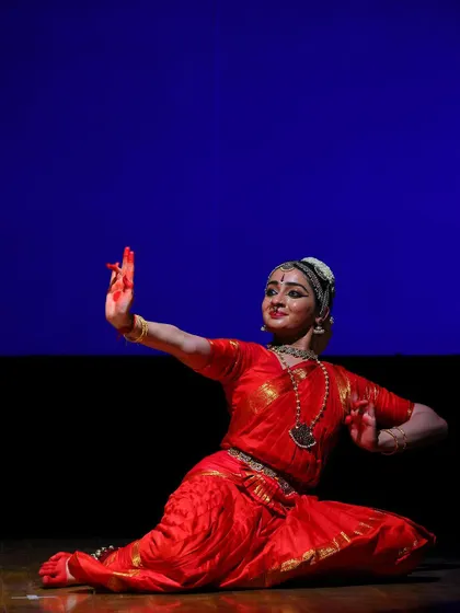 A seated pose that combines grace with a strong posture. This is from a narrative section of the performance, depicting a moment of storytelling.