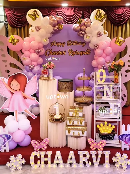The full stage setup for Chaarvi's party, with large butterfly wing props.