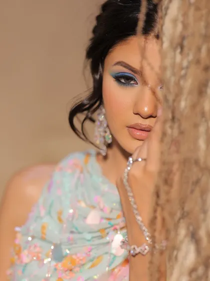 A final, mysterious shot of the carnival look. The play of shadows and the peek of blue eyeshadow is captivating.