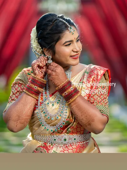 Neelima adjusting her earring, providing a great look at the complete set against her beautiful silk saree.