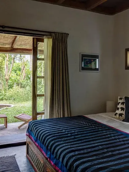 The Garden Room bedroom opens onto a private terrace with a small pond, creating a personal sanctuary.