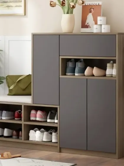 A compact and modern shoe storage cabinet with a cushioned seating area. This piece combines open cubbies for everyday shoes and closed cabinets for a tidy look.