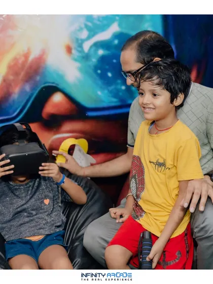 A father helps his child with a VR headset, showcasing a heartwarming moment of family fun at our IIT Delhi event.