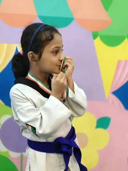A champion's moment. Zainab kisses her gold medal, a symbol of her hard-earned victory.