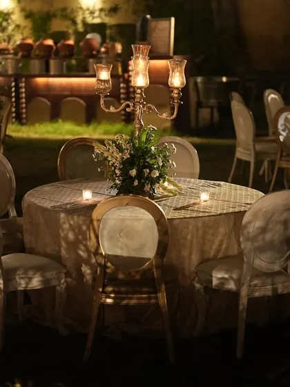 An intimate dinner setting with a classic candelabra centerpiece, exuding timeless elegance for the sangeet night.