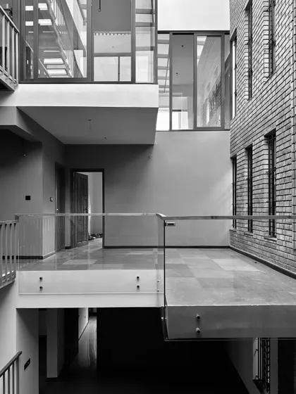 A work-in-progress shot from a residence in Thrissur, Kerala. This black and white photo captures the raw beauty of the structure, showcasing the interplay of brick, concrete, and the multi-level interior spaces during construction.