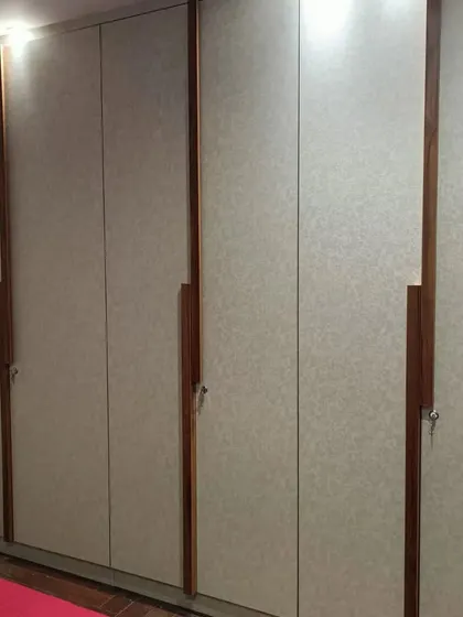 A delivered modular wardrobe with a simple, clean design. The light-colored laminate and long wooden handles create a minimalist and timeless look.