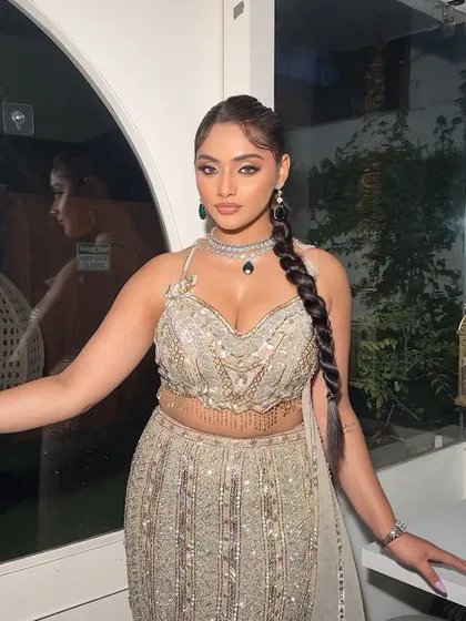A front view of the model showcasing the sleek twisted braid. The hair is pulled back cleanly to highlight the face, while the braid adds a touch of modern sophistication.