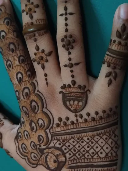 A simple and sweet design featuring peacock feather motifs and delicate patterns on the fingers. It's a great choice for young girls or for a minimal look.