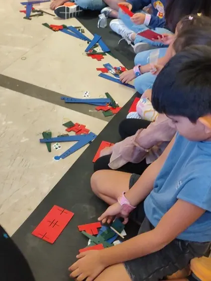 A close-up of the building process. Kids work with various components, learning how different parts fit together to create a functional machine.