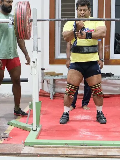 Adjusting my wrist wraps before a heavy squat at the railway camp. Every detail of the setup matters for a successful lift.