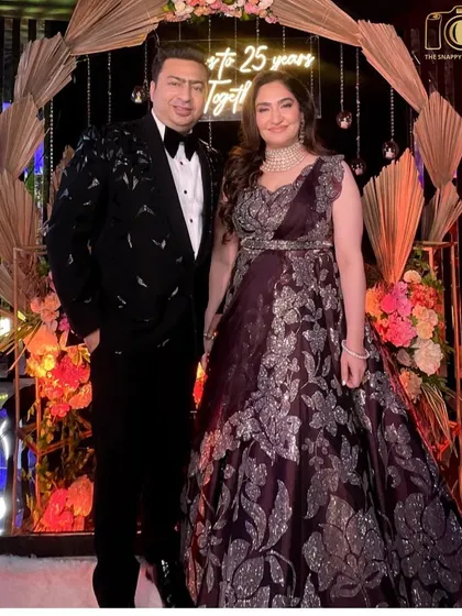 Celebrating a silver jubilee! The happy couple marking 25 years together, looking absolutely regal in front of a custom backdrop.