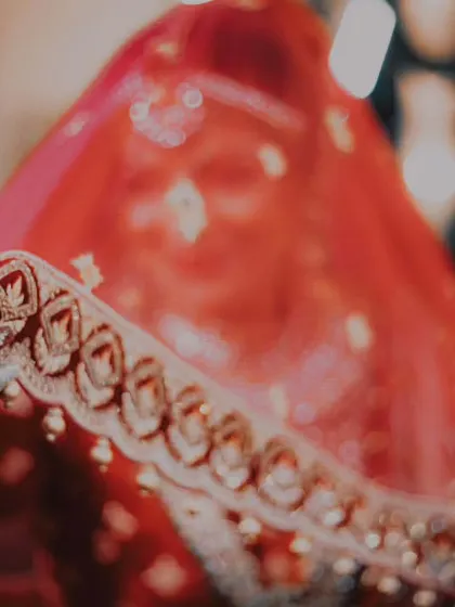 Dreamy vibes, forever memories. A close-up of the bride's hand and veil, focusing on the intricate details of her attire.