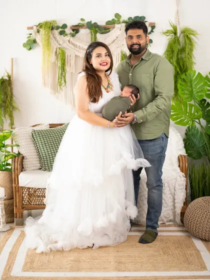 A full-length family portrait with a newborn in our boho studio. The coordinating outfits and natural decor create a warm and cohesive family picture.