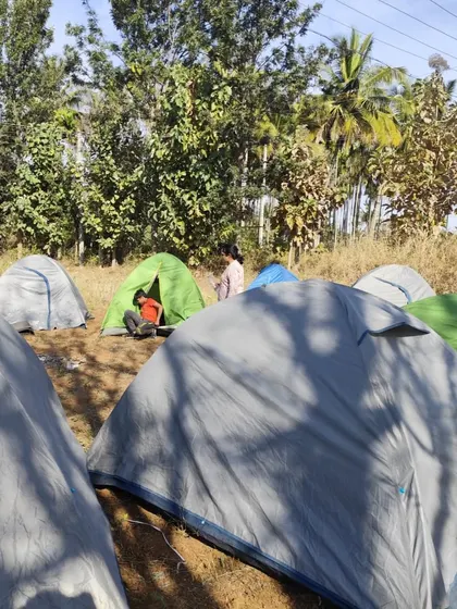 A view of our campsite with multiple tents pitched in a field. We provide all the necessary camping gear.