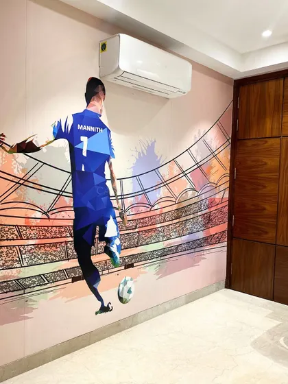 A fantastic custom wall mural of a football player makes this room a dream for any young sports fan, adding a dynamic and personal touch to the space.