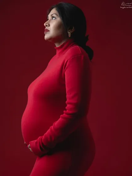 A bold and powerful statement. A simple, form-fitting red dress against a matching red background creates a stunning monochrome color portrait.