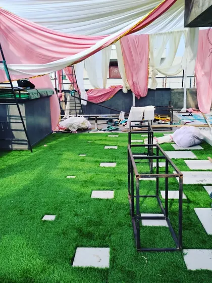 The terrace is starting to take shape. The combination of the thick green turf and stone pavers creates a premium, landscaped look, even during a party setup.
