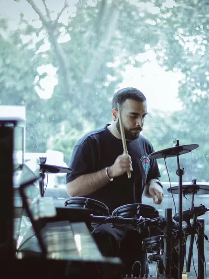 A student drummer laying down a beat during the recital. We provide opportunities for students to perform on both acoustic and electronic drum kits.
