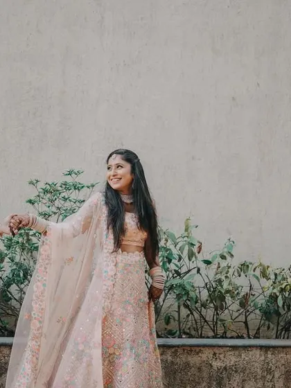 A candid "leading hand" shot from an engagement session. The soft, pastel outfits of the couple complement the gentle and romantic mood.