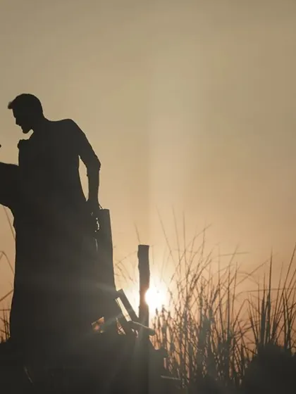 A classic romantic silhouette against a golden sunset, capturing the couple in a timeless dance pose.