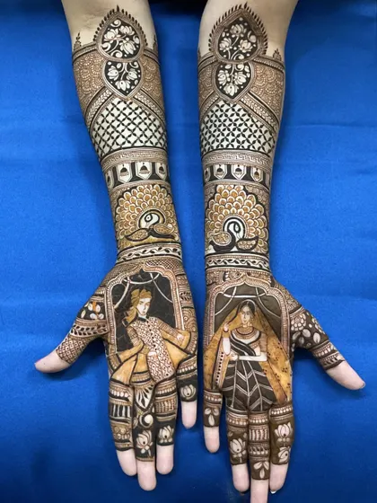 A classic bride and groom portrait design, showcasing the rich, dark stain from my natural henna. The figures are framed beautifully, with detailed jaali work and peacock motifs extending up the forearms.