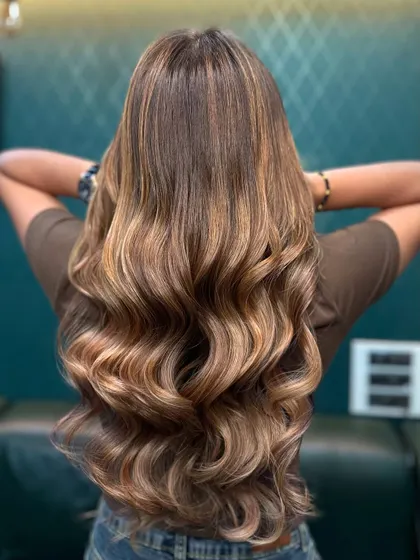 A perfect mix of trendy and timeless. This look combines warm blonde tones with a darker root for a lived-in, effortless feel.