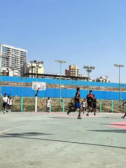 A wide shot of our team playing during the Navrang Fest. The open court and clear skies were the perfect setting for a day of competitive basketball.