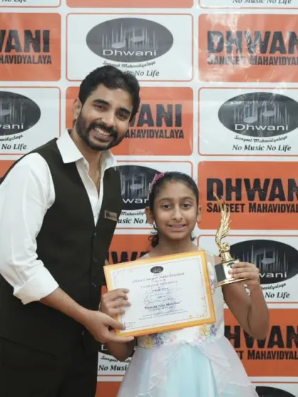 A teacher presents an award to his student, a moment of pride for both guru and shishya.