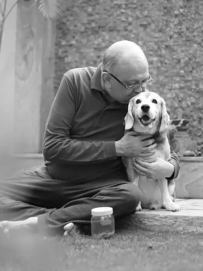 A touching black and white photo of a man kissing his senior Beagle, Leo, on the head, capturing a moment of deep love and companionship.
