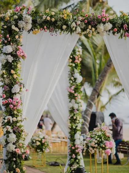 A close-up of the floral decoration on the wedding aisle archway, featuring a beautiful mix of pink and white roses for a classic, romantic look.