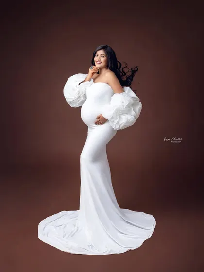 A profile view that showcases the stunning silhouette of the white gown and its unique, cloud-like sleeves.