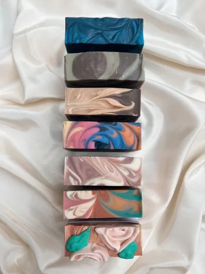 Soap tops are my canvas. This stack shows the variety of swirls, layers, and piped details from one of my recent collections.